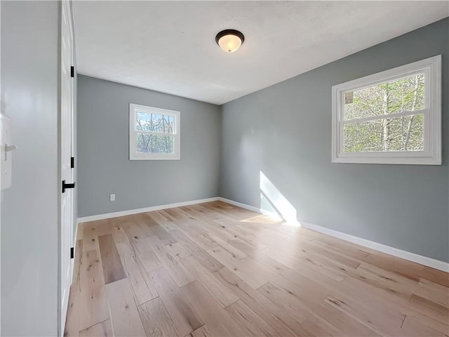 empty room with light wood finished floors and baseboards