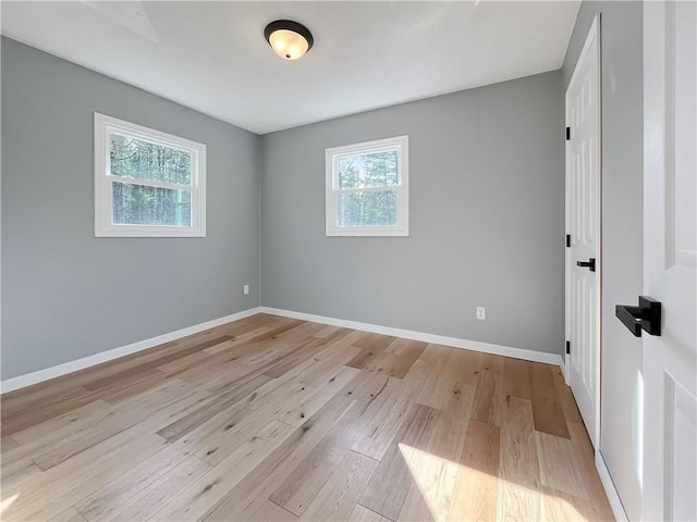 empty room featuring light wood-type flooring and baseboards