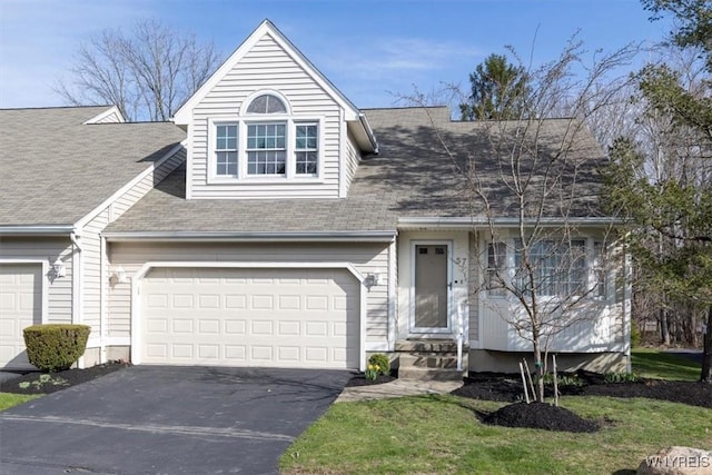 view of front of house featuring a garage, aphalt driveway, and roof with shingles