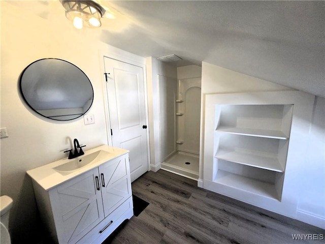 full bath featuring a stall shower, wood finished floors, and vanity