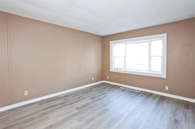 9 Renwood St, Rochester, NY 14621 - empty room with visible vents, baseboards, a decorative wall, wood finished floors, and a drop ceiling