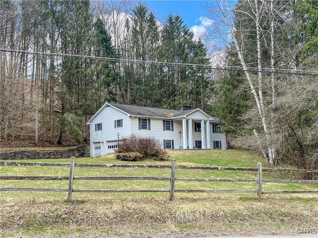 6449 W Scott Rd, Scott, NY 13077 - bi-level home featuring a garage, a chimney, and a view of trees