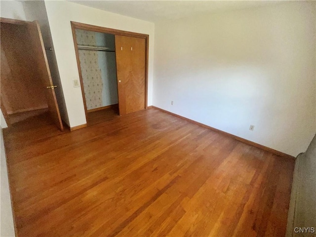 6449 W Scott Rd, Scott, NY 13077 - unfurnished bedroom featuring wood finished floors, baseboards, and a closet