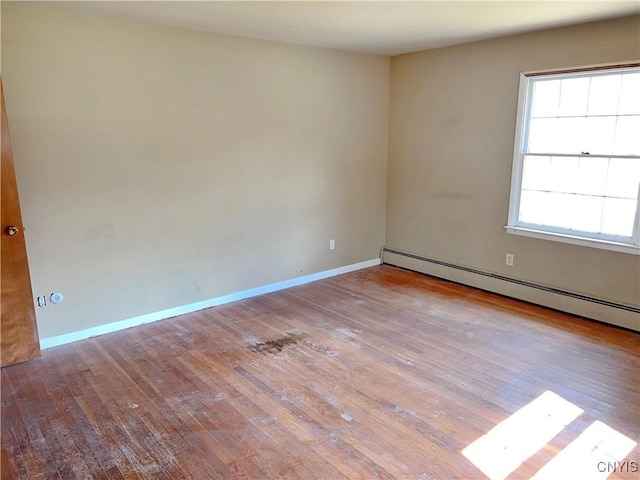 6449 W Scott Rd, Scott, NY 13077 - unfurnished room with baseboard heating, hardwood / wood-style flooring, and baseboards