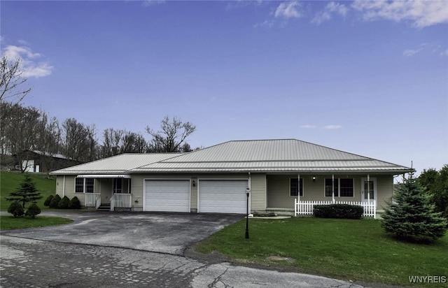 single story home with driveway, a front lawn, a porch, a garage, and metal roof