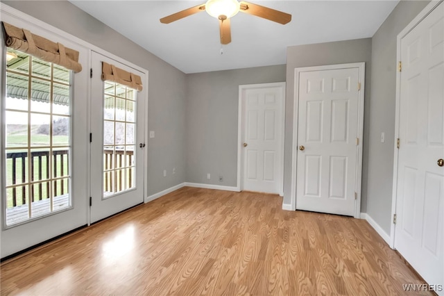 doorway featuring light wood-type flooring, baseboards, and ceiling fan