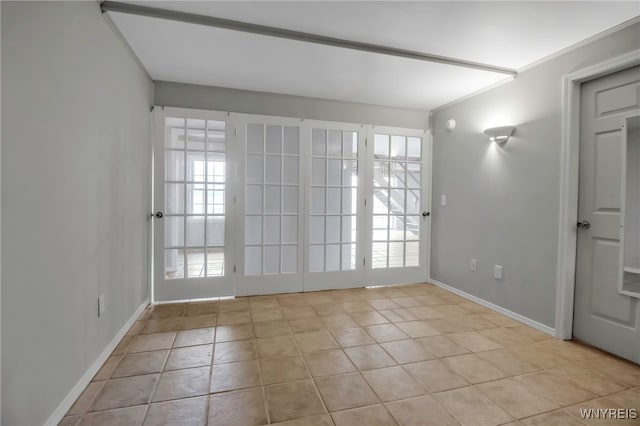 spare room featuring a wealth of natural light, baseboards, and light tile patterned flooring