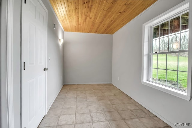 empty room with baseboards and wood ceiling