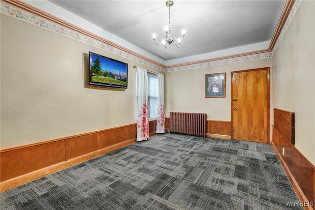 2300 Main St, Buffalo, NY 14214 - empty room featuring radiator heating unit, carpet, an inviting chandelier, and wainscoting