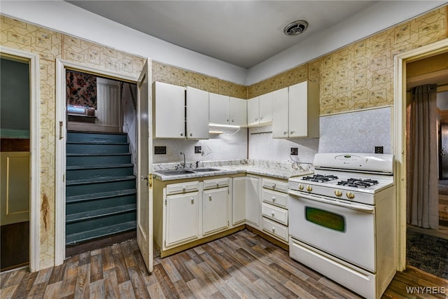 2300 Main St, Buffalo, NY 14214 - kitchen with wallpapered walls, white range with gas cooktop, light countertops, visible vents, and a sink