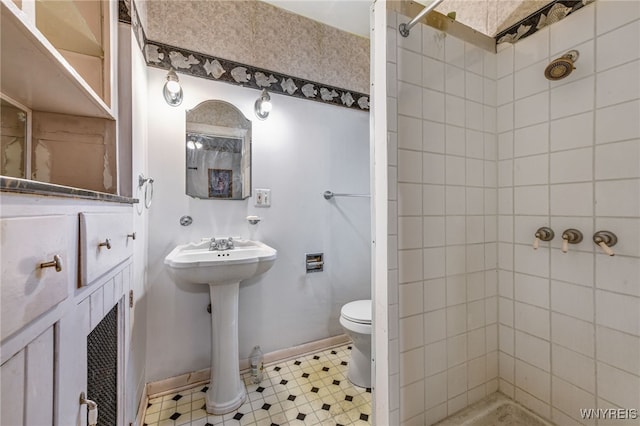 2300 Main St, Buffalo, NY 14214 - full bathroom featuring baseboards, a sink, toilet, a tile shower, and tile patterned floors