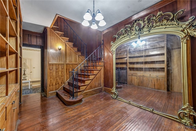 2300 Main St, Buffalo, NY 14214 - stairway with wood walls, hardwood / wood-style floors, and a notable chandelier