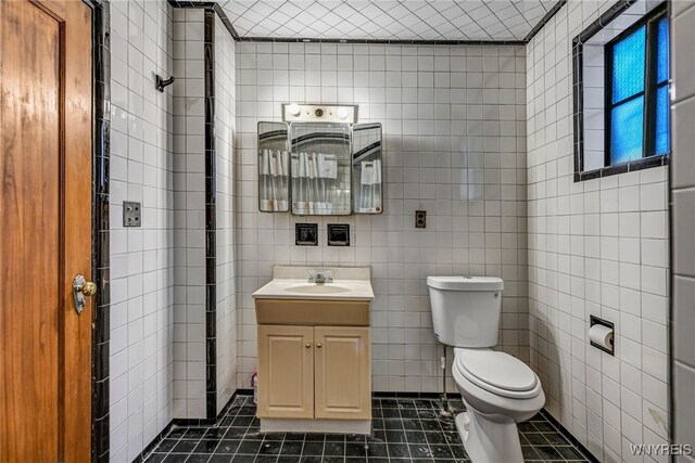 2300 Main St, Buffalo, NY 14214 - bathroom featuring tile walls, vanity, tile patterned flooring, and toilet