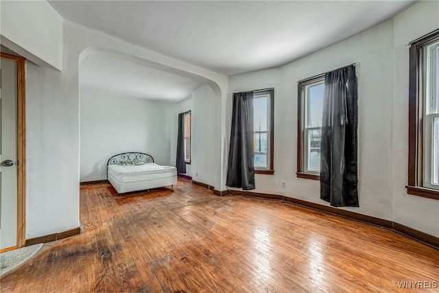 2300 Main St, Buffalo, NY 14214 - unfurnished room with baseboards, arched walkways, and hardwood / wood-style floors