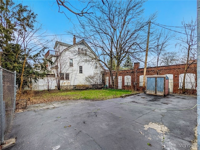 2300 Main St, Buffalo, NY 14214 - rear view of house with fence, a balcony, and a chimney