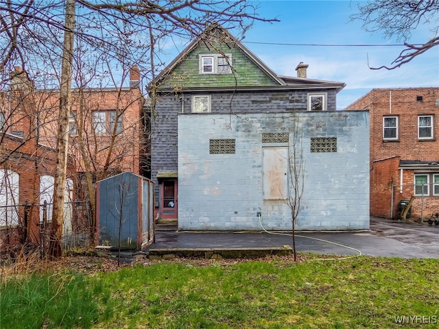 2300 Main St, Buffalo, NY 14214 - back of property with a storage shed, a chimney, fence, and an outbuilding