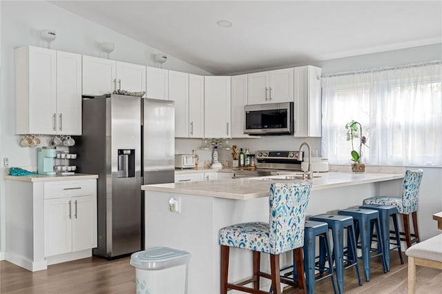 6186 Reservoir Rd, Lebanon, NY 13346 - kitchen with appliances with stainless steel finishes, a peninsula, wood finished floors, lofted ceiling, and white cabinets