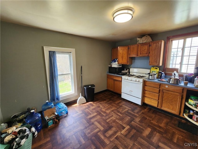 903 Milton Ave, Syracuse, NY 13204 - kitchen with brown cabinetry and white range with gas stovetop