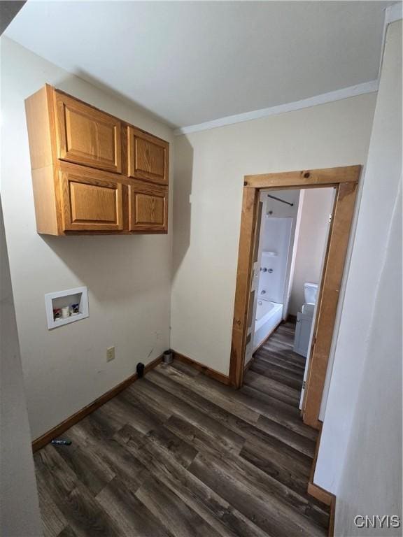 laundry room with crown molding, hookup for a washing machine, dark wood-type flooring, baseboards, and cabinet space