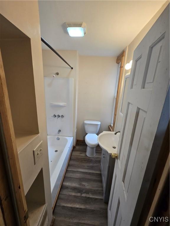 full bathroom with toilet, shower / tub combination, vanity, and wood finished floors