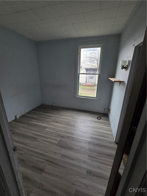 spare room with baseboards and wood finished floors