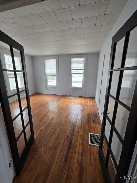spare room with wood-type flooring and visible vents