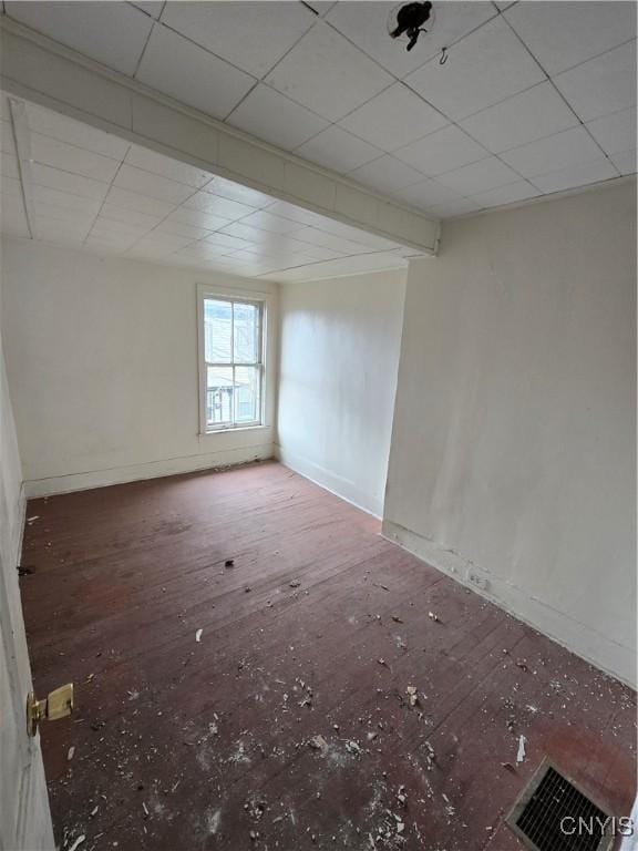 unfurnished room with a paneled ceiling, baseboards, and visible vents