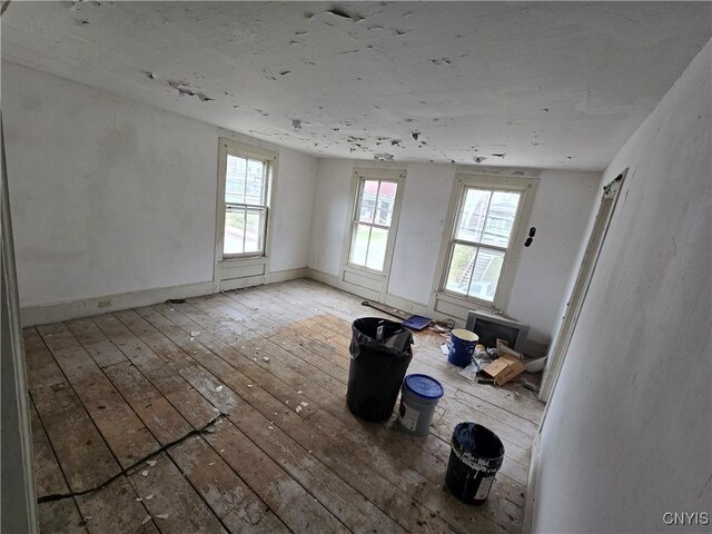 spare room featuring wood-type flooring and baseboards