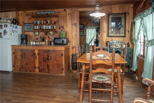 dining space with wood walls and wood finished floors