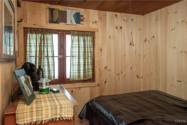 bedroom featuring wooden walls and french doors