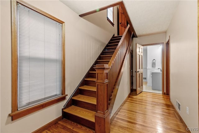 staircase featuring hardwood / wood-style floors and baseboards