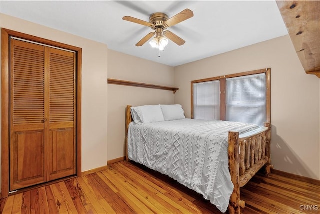 bedroom with baseboards, light wood-type flooring, a closet, and ceiling fan
