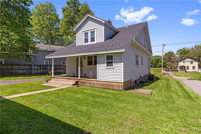 view of front of home with a porch, roof with shingles, and central AC