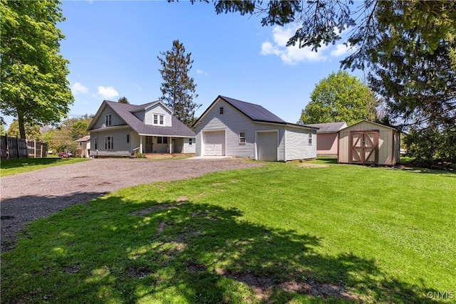 view of front of house featuring an outdoor structure, a detached garage, a storage unit, and driveway