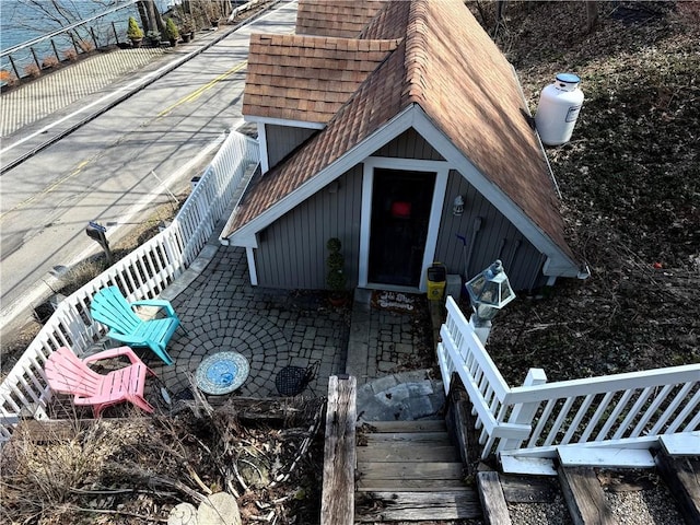 6761 State Highway 80, Otsego, NY 13326 - property entrance featuring a shingled roof, board and batten siding, and a patio area