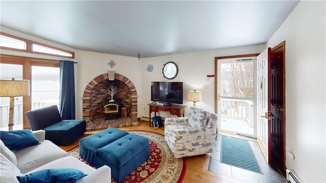 6761 State Highway 80, Otsego, NY 13326 - living room featuring baseboard heating, a wood stove, and wood finished floors