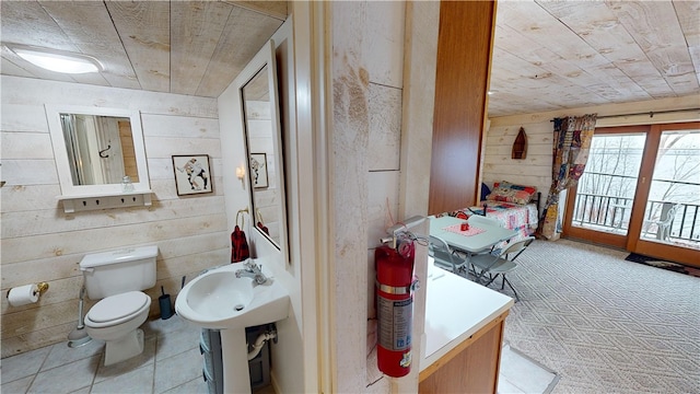 6761 State Highway 80, Otsego, NY 13326 - half bathroom with wooden ceiling, toilet, wooden walls, and tile patterned floors