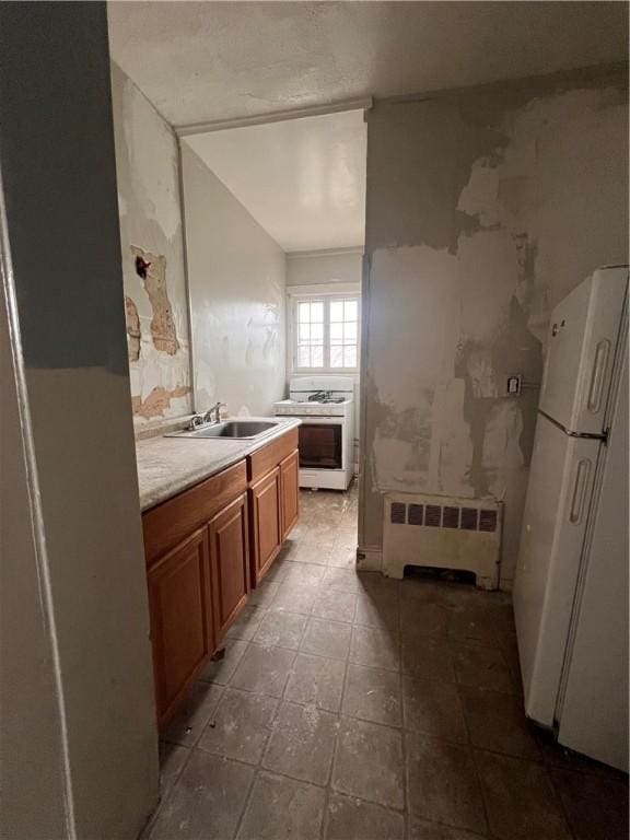 bathroom with radiator, tile patterned floors, and a sink