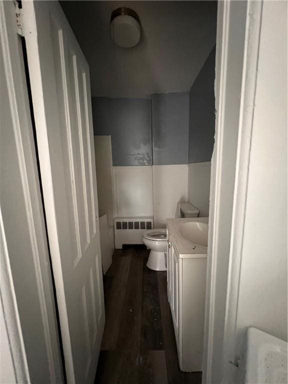 bathroom featuring radiator heating unit, toilet, vanity, and wood finished floors