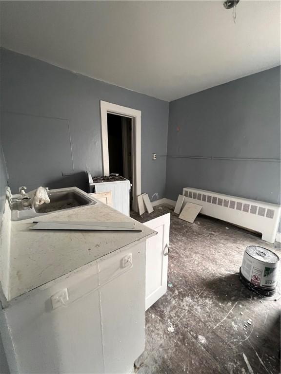 interior space with radiator heating unit, washer / clothes dryer, and a sink