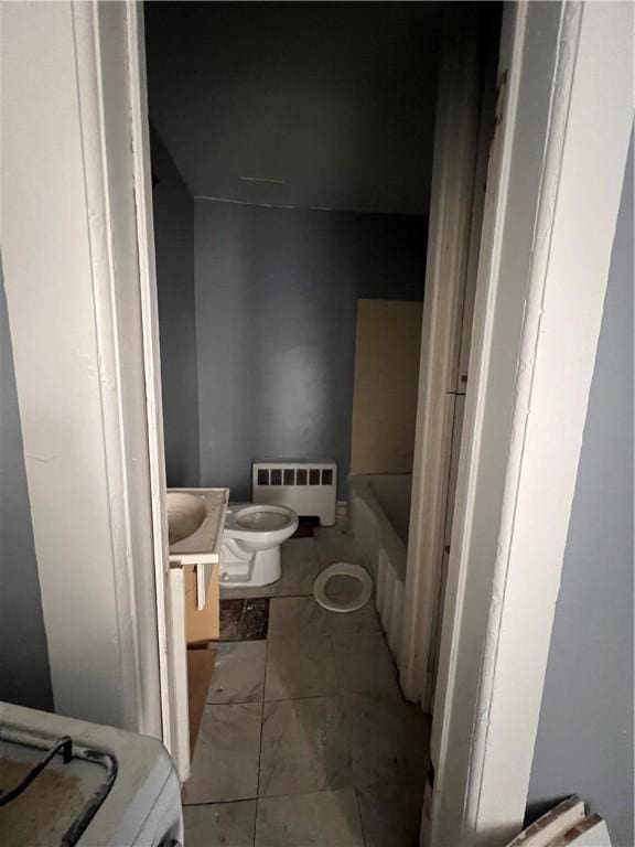bathroom with a bathtub, toilet, radiator heating unit, tile patterned flooring, and vanity