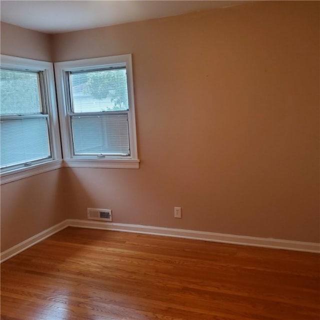 unfurnished room featuring wood finished floors and baseboards