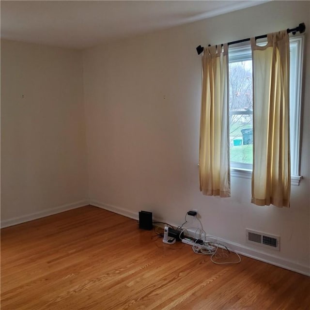 spare room with light wood-style flooring and baseboards