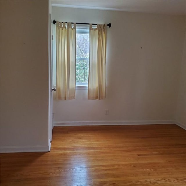 unfurnished room featuring light wood-type flooring and baseboards