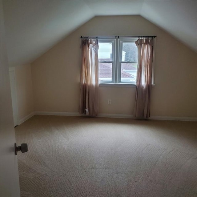 bonus room with carpet flooring, lofted ceiling, and baseboards