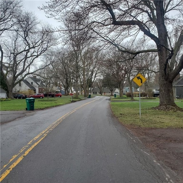 view of asphalt street with traffic signs and a residential view