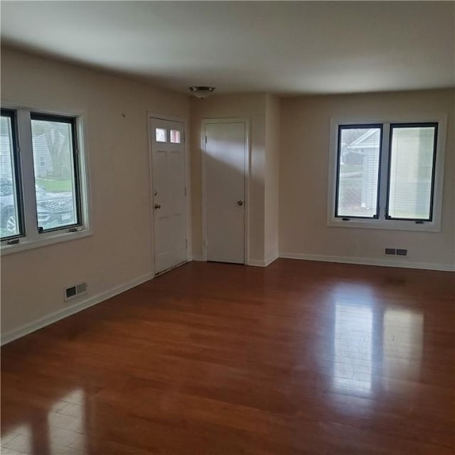 foyer featuring wood finished floors, healthy amount of natural light, and baseboards