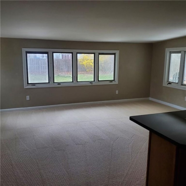 carpeted empty room featuring baseboards