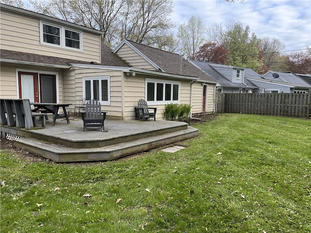 back of property with a wooden deck and a shingled roof