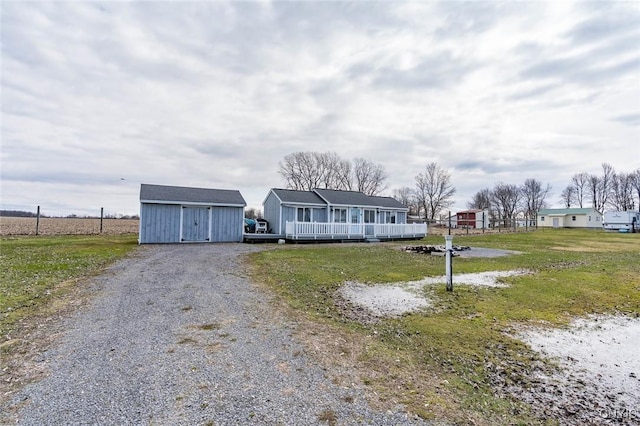 27180 Montonna Shores Rd N, Lyme, NY 13693 - view of front of house featuring an outdoor structure, a storage unit, gravel driveway, and a front yard